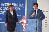 Na fotografii widać przemawiającego Posła na Sejm RP Tomasza Głogowskiego. Obok niego stoi Dyrektor Szkoły Małgorzata Grzesiakowska.