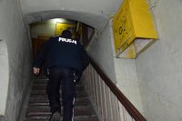Na fotografii widać klatkę schodową. Po schodach wchodzi policjant