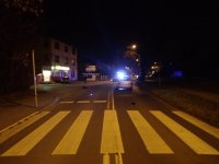 Na fotografii widać przejście dla pieszych, za którym widać samochód osobowy. W tle fotografii widać policyjny radiowóz blokujący drogę.