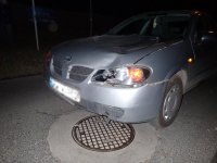 Na fotografii widać przód samochodu osobowego. Auto ma rozbity reflektor oraz uszkodzoną maskę.