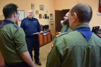 Na fotografii widać  Komendanta Powiatowego Policji w Tarnowskich Górach insp. Krzysztofa Hajdę oraz obróconych tyłem harcerzy.