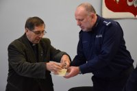 Na fotografii widać Komendanta Powiatowego Policji w Tarnowskich Górach insp. Krzysztofa Hajdę oraz księdza Joachima Gondro, którzy dzielą się opłatkiem.