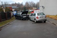 Na fotografii widać dwa samochody osobowe, które zderzyły się czołowo. W tle zdjęcia widać policyjny radiowóz oraz wóz strażacki.