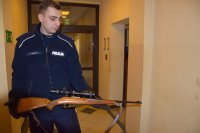 Na fotografii widać policjanta, który w dłoniach trzyma broń myśliwską