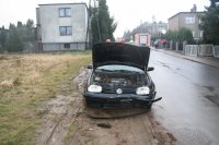Na fotografii widać rozbity przód samochodu osobowego. Auto ma podniesioną do góry maskę