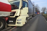 Na fotografii widać ulicę, na której zderzyły się ze sobą dwa samochody ciężarowe. Za pojazdami widać ciąg samochodów