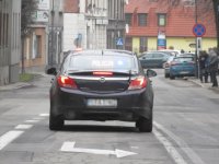 Na fotografii widać drogę, po której jedzie nieoznakowany radiowóz policyjny