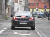 Na fotografii widać drogę, po której jedzie nieoznakowany radiowóz policyjny