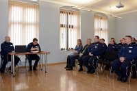przy stoliku siedzi od prawej Pierwszy Zastępca Komendanta Wojewódzkiego Policji w Katowicach insp. Roman Rabsztyn oraz  Komendant Powiatowy Policji w Tarnowskich Górach insp. Krzysztof Hajda. Z prawej strony zdjęcia widać siedzących na krzesłach policjantów oraz zaproszonych gości.