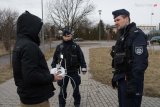 zdjęcie przedstawia dwóch policjantów rozmawiających z mężczyzną, który trzyma w dłoni urządzenie do kontrolowania drona
