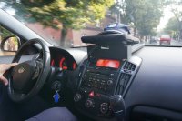 na fotografii widać wnętrze policyjnego radiowozu. Przez przednią szybę widać  samochody osobowe