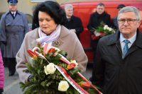 Posłanka na Sejm Barbara Dziuk niesie wiązankę kwiatów. W tle fotografii widać m.in.  Pierwszego Zastępcę Komendanta Powiatowego Policji w Tarnowskich Górach podinsp. Sławomira Bylickiego
