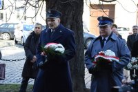 fotografia kolorowa.  Pierwszy Zastępca Komendanta Powiatowego Policji w Tarnowskich Górach podinsp. Sławomir Bylicki wraz z Dyrektorem Aresztu niosą wiązanki kwiatów