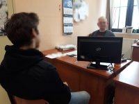 na zdjęciu: zatrzymany mężczyzna siedzi przy biurku w trakcie przesłuchania