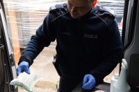 na zdjęciu: policjant w trakcie przeglądu środków do dezynfekcji