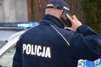 Policjant ma przyłożony do ucha telefon komórkowy