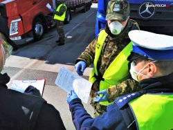 zdjęcie przedstawia funkcjonariuszy w maseczkach - policjanta i strażnika granicznego