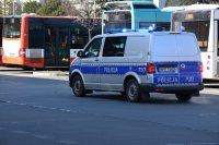 fotografia kolorowa: policyjny radiowóz przemieszcza się przez dworzec autobusowy