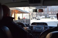 fotografia kolorowa: wnętrze radiowozu. Na przednich fotelach siedzą policjanci