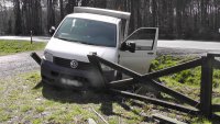 fotografia kolorowa: na zdjęciu widać samochód, który wjechał w ogrodzenie przydrożnego parkingu leśnego