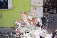 Na zdjęciu widać róg ściany budynku. Elewacja jest zniszczona, widać pustaki
