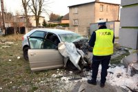 na zdjęciu widać policjanta, który stoi przed kompletnie zniszczonym samochodem osobowym