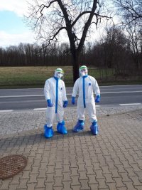 na zdjęciu widać dwóch policjantów ubranych w kombinezony ochronne