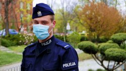 na zdjęciu widać policjanta, który na twarzy ma maseczkę ochronną