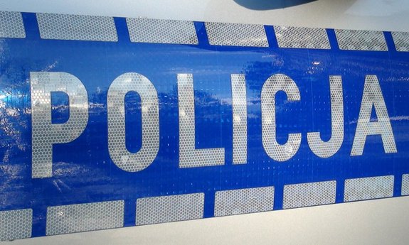 na zdjęciu widać bok policyjnego radiowozu z napisem policja