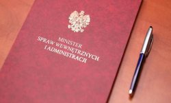 Na zdjęciu widać czerwoną teczkę z godłem, na której jest napisane Minister Spraw Wewnętrznych i Administracji