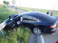 Na zdjęciu widać samochód osobowy, przodem &quot;wbity &quot; w przydrożną barierę. Auto jest zniszczone.