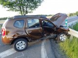Na zdjęciu widać samochód osobowy, którego przód jest &quot;wbity&quot; w przydrożną barierę. Bok samochodu i przód jest zniszczony.
