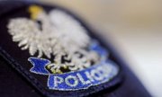 Godło Polski naszyte na policyjną czapkę. Pod godłem napis policja