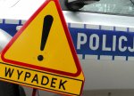 Grafika: znak ostrzegawczy z tabliczką wypadki. W tle widać policyjny radiowóz