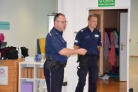 fotografia kolorowa: dwóch policjantów rozmawia z dziećmi