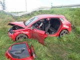 Na fotografii widać kompletnie zniszczony samochód osobowy, który stoi w przydrożnym rowie