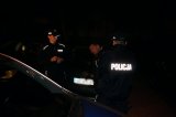Na fotografii widać dwóch policjantów interweniujących wobec mężczyzny. Interwencja przebiega w nocy.