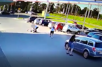 zdjęcie przedstawia parking przed jednym ze sklepów na którym mężczyźni dokonują rozboju