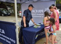 policjant rozmawiający z dziećmi i kobieta