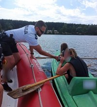 zdjęcie przedstawia akwen, na środku którego, policjant sprawdza stan trzeźwości osób pływających kajakiem