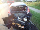 Na fotografii widać samochód osobowy. Pojazd ma zgnieciony tył oraz wybitą tylną szybę. W środku widać otwarte poduszki powietrzne
