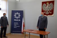 Na zdjęciu widać Komendanta Powiatowego Policji w Tarnowskich Górach insp. Krzysztofa Hajdę oraz Naczelnika Wydziału Prewencji kom. Piotra Skolika. Za Komendantem widać godło, a z jego prawej strony, policyjny baner i flagę.