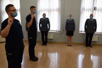 Zdjęcie przedstawia ślubujących policjantów. W tle fotografii widać Naczelnika Wydziału Ruchu Drogowego asp. szt. Marceli Zymela, Kierownika Ogniwa Patrolowo-Interwencyjnego asp. szt. Grzegorza Grabowskiego oraz Specjalistę Zespołu Kadr i Szkolenia asp. szt. Anetę Bartoszewską.