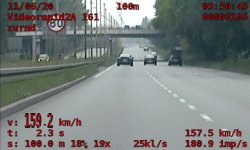 Zdjęcie przedstawia widok z policyjnego wideorejestratora. Widać drogę, po której poruszają się pojazdy, znak ograniczenia prędkości do 80 km/h i pomiar z wideorejestratora, który pokazuje prędkość samochodu 159,2 km/h
