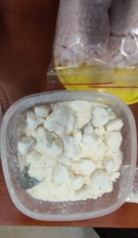 Na zdjęciu widać plastikowy pojemnik, w którym znajduje się biała, zbrylona substancja