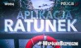 Grafika - widok jeziora w lasie i gór, na poręczy wisi koło ratownicze. Tekst na grafice - Aplikacja Ratunek #WspólnieBezpieczni