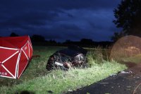 Na fotografii widać: W przydrożnym rowie czerwony parawan z napisem STRAŻ, obok którego znajduje się rozbity Nissan Qashqai.