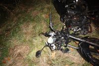 Zdjęcie przedstawia leżący na trawie, rozbity motorower
