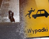 Grafika - z lewej strony na przejściu dla pieszych leży but, z prawej strony znak – piktogram auto potrąca człowieka. Pod znakiem napis wypadki