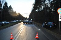 Na zdjęciu widać drogę, w poprzek której stoi rozbita skoda a w rowie leży ford. Z lewej strony zdjęcia widać przydrożny parking, na którym są zaparkowane samochody.